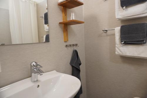 a bathroom with a sink and a mirror and towels at Nygården Stjärnholm in Nyköping