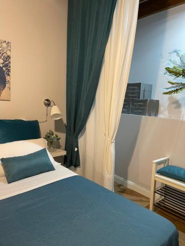 una camera con un letto blu e bianco e una finestra di Loft Penelope a Tivoli
