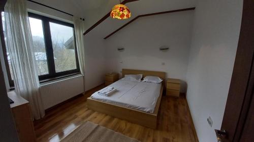a small bedroom with a bed and a window at Breaza - Grădina Ascunsa in Breaza