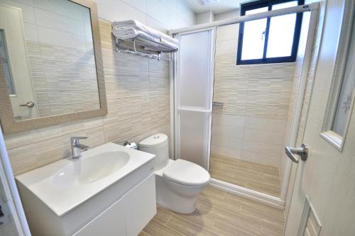a bathroom with a toilet and a sink and a shower at v2民宿 in Taitung City