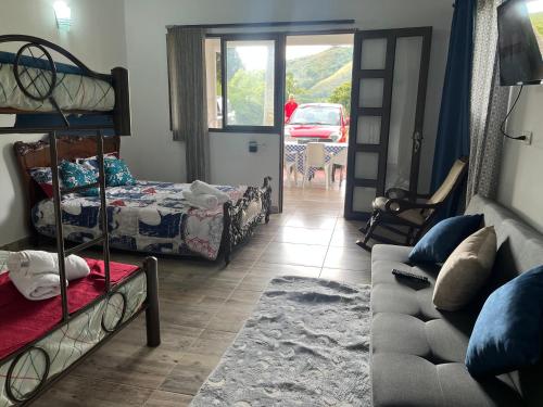 a room with bunk beds and a living room with a couch at Monteverde Holiday Apartments in Buga