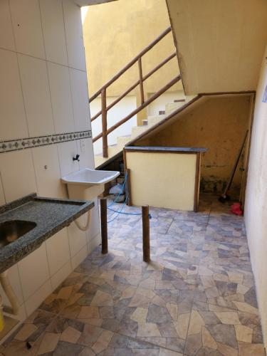 an empty room with a sink and a staircase at Casa de praia in Arembepe