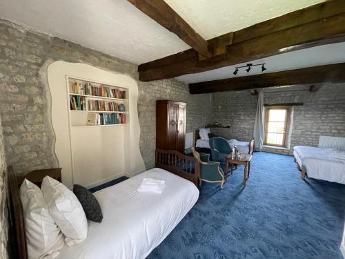 a bedroom with a white bed and a brick wall at La Ferme Delaunay in Saint-Côme-du-Mont