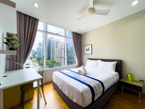 a bedroom with a bed and a desk and a window at Vortex suites klcc by Surat in Kuala Lumpur