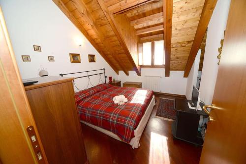 a bedroom with a bed with a cat laying on it at Trilocale Alpinsun - Accoglienza per 5 persone in Sozzine