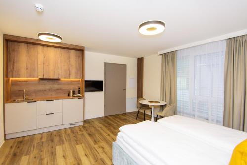 Habitación de hotel con cama, mesa y ventana en Hotel TwentyFour Living en Bad Urach