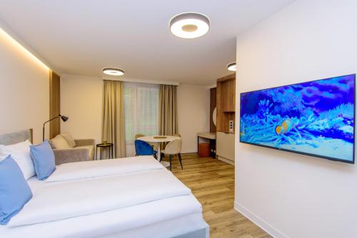 Habitación de hotel con 2 camas y un acuario en la pared en Hotel TwentyFour Living en Bad Urach
