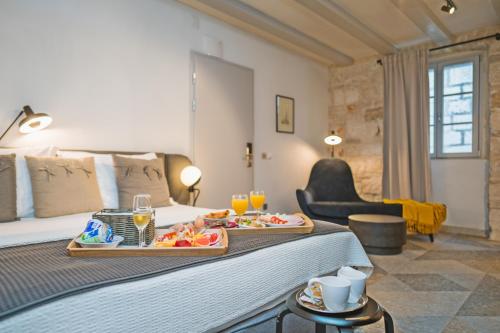 ein Hotelzimmer mit einem Bett und einem Tablett mit Essen darauf in der Unterkunft Zuviteo Residence in Korčula