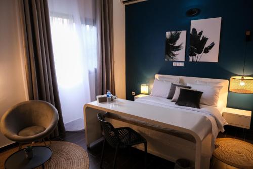 a bedroom with a bed and a chair and a window at Villa Ayaba in Abidjan