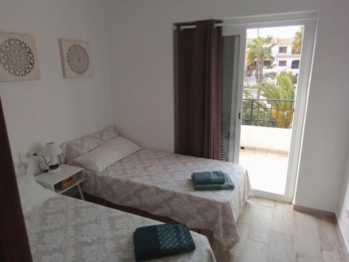 a small bedroom with two beds and a balcony at Kalle Blanca - Cabo Roig in Cabo Roig