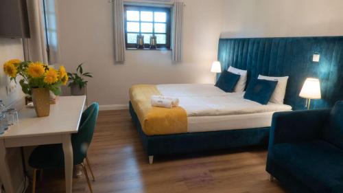 a hotel room with a bed with a blue headboard at Kanclerz in Zamość