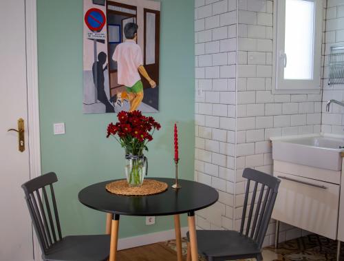 - une table à manger avec un vase de fleurs dans l'établissement Nido MAD, à Madrid