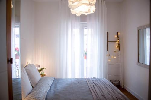 馬德里的住宿－Nido MAD，一间卧室配有一张床和一个吊灯