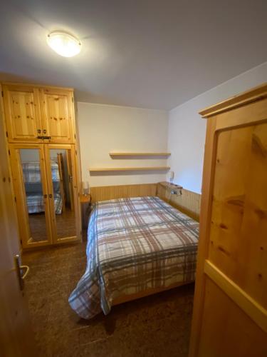 Un dormitorio con una cama y un armario. en Appartamento Aprica vicinissimo alle piste sci, en Aprica