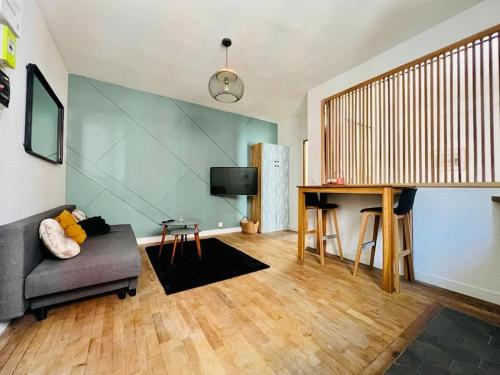 ein Wohnzimmer mit Sofa und Tisch in der Unterkunft Joli Appartement à 15min des Champs Elysée in Saint-Ouen