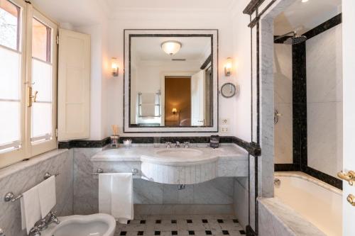 a bathroom with a sink and a large mirror at QC Grand Hotel Roma in Fiumicino