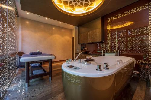 uma casa de banho com uma banheira e um lavatório em Vanagupe Spa Resort em Palanga