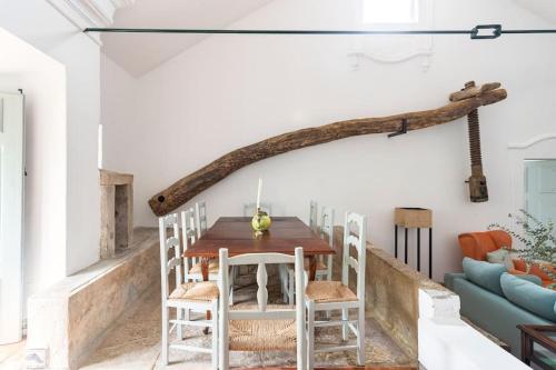 a dining room with a wooden table and chairs at Quinta de Cima,No campo é Assim in Vila Franca de Xira