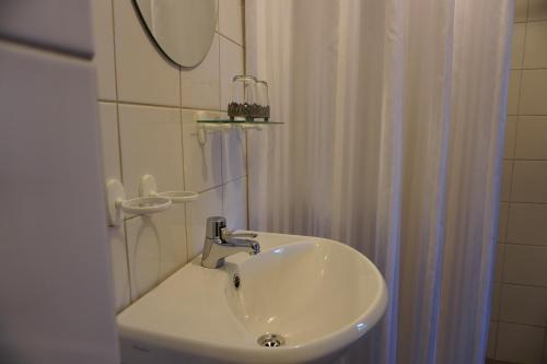 lavabo blanco en el baño con espejo en Stjärnholmsslott en Nyköping