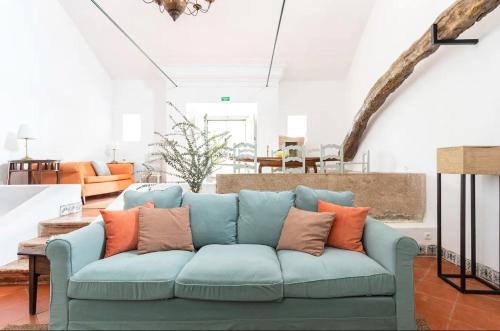 a living room with a blue couch with orange pillows at Quinta de Cima,No campo é Assim in Vila Franca de Xira