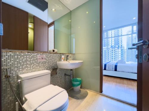 baño con aseo y lavabo con ventana en Soho Suites klcc by i.desk, en Kuala Lumpur