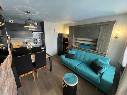 Il comprend un salon avec un canapé bleu et une cuisine. dans l'établissement Appt 123 Home Club Tignes, à Tignes