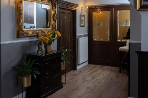 korytarz z lustrem i komodą z kwiatami w obiekcie Kanclerz w mieście Zamość