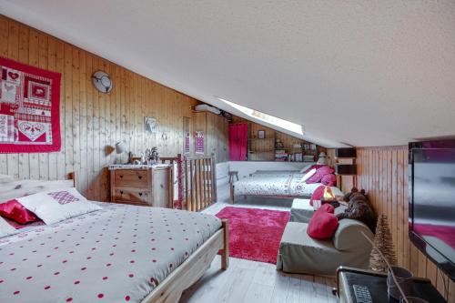 a bedroom with two beds and a couch at L'Edelweiss - Au pied des pistes in Enchastrayes