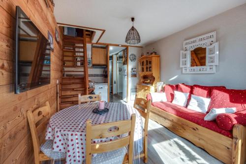 a living room with a red couch and a table at L'Edelweiss - Au pied des pistes in Enchastrayes