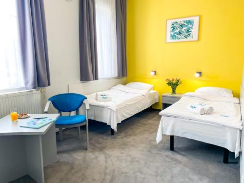 una habitación de hospital con 2 camas y una silla azul en Hotel Jabłoński, en Dorotowo