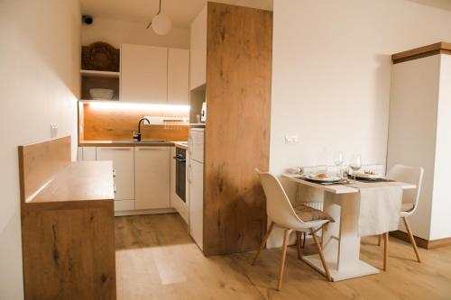 a kitchen with a table and chairs in a room at Miadora apartments - Apartma Rusalka in Moravske Toplice