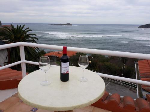 a table with two glasses and a bottle of wine at Mundaka Vista Mar L-BI-52 in Mundaka