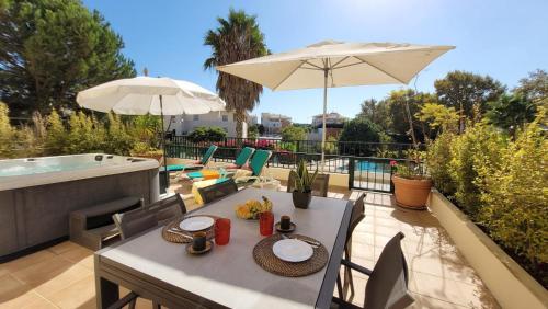 a table and chairs with an umbrella on a patio at Place in the sun - Free out door Jacuzzi - BY BEDZY in Albufeira
