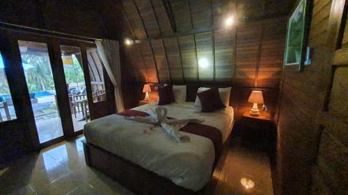 ペニダ島にあるKelingking Tatakan Bungalowのベッドルーム1室(ベッド1台、鳥付)