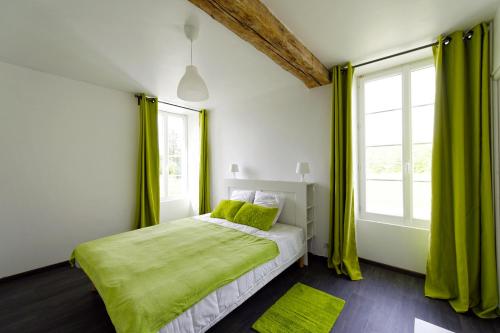 Schlafzimmer mit einem Bett mit grüner Bettwäsche und Fenstern in der Unterkunft LA MARSEILLAISE 15 PERS PISCINE in Étais-la-Sauvin
