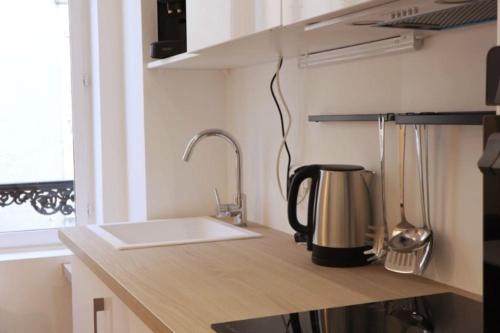 a kitchen counter with a sink and a coffee maker at Le Doux Refuge à quelques pas de la Cathédrale in Chartres