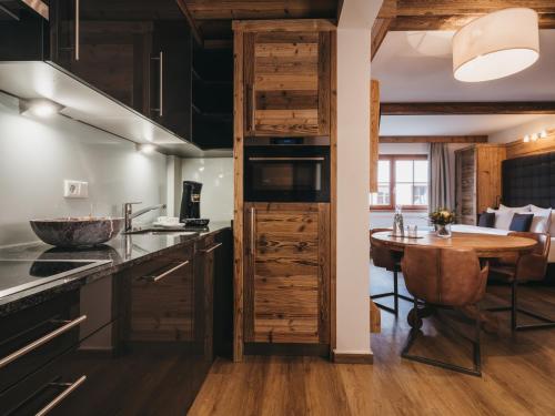 a kitchen with wooden cabinets and a wooden table at VAYA Kaprun inklusive Zell am See Kaprun Sommer Karte in Kaprun