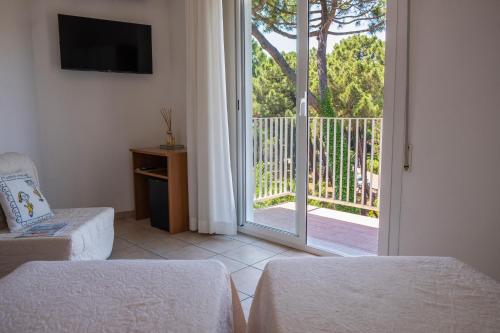 a room with a sliding glass door to a balcony at Hotel Orsa Maggiore in Milano Marittima