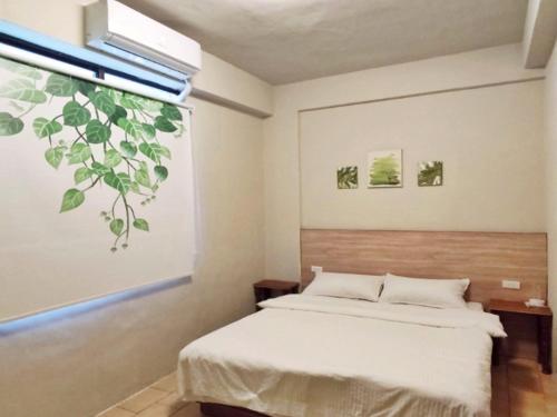 a bedroom with a bed and a window at 翼想旅宿-2022營運車站前花蓮民宿 in Hualien City