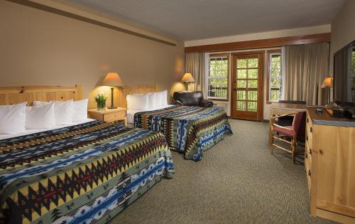 a hotel room with two beds and a desk at Heathman Lodge in Vancouver