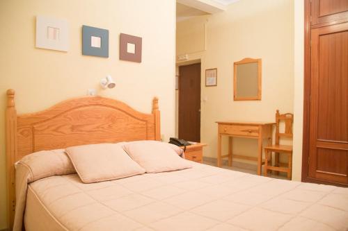 sypialnia z dużym łóżkiem i biurkiem w obiekcie Hostal Sierpes w Sewilli