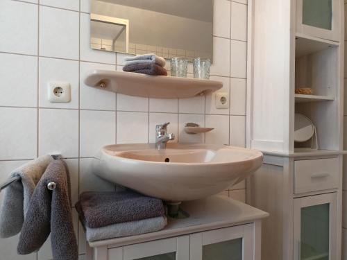 een witte badkamer met een wastafel en handdoeken bij Ferienwohnung Sonne in Bad Windsheim