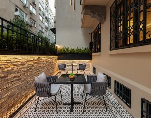 eine Terrasse mit einem Tisch und Stühlen im Innenhof in der Unterkunft Gleam Collection Hotel in Istanbul