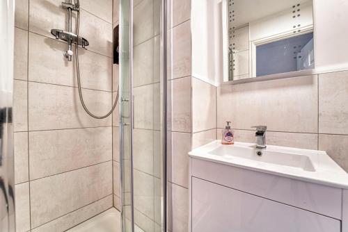 a bathroom with a shower and a sink and a mirror at Guest Homes - Lion Court in Worcester