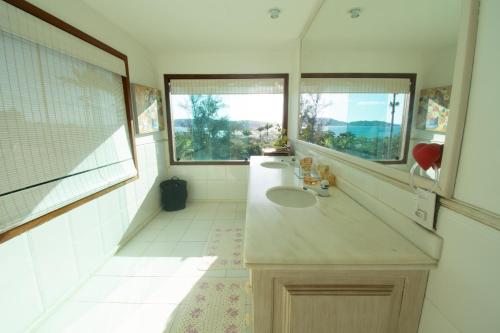 a bathroom with two sinks and two windows at Pousada Bella Vista Geribá in Búzios