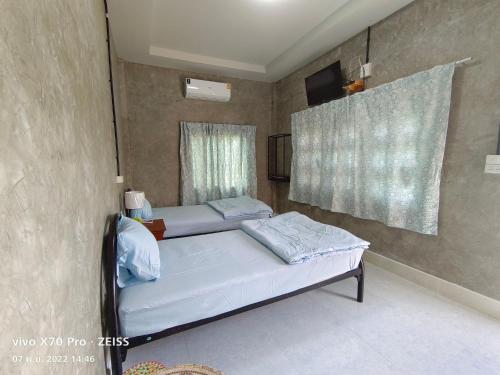 1 dormitorio con 2 camas y ventana en Da-Kanda Boutique, en Klong Muang Beach