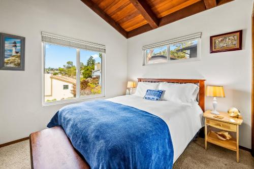 a bedroom with a large bed and two windows at All Decked Out in Cambria in Cambria