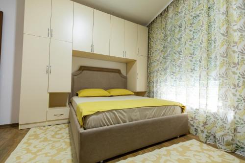 um quarto com uma cama e uma grande janela em Tirana Contact Apartment em Tirana