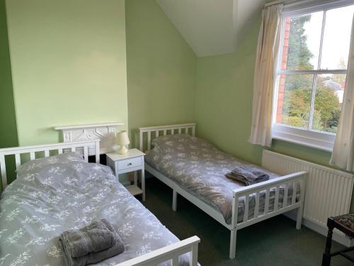 a bedroom with two beds and a window at Spring View in Little Malvern