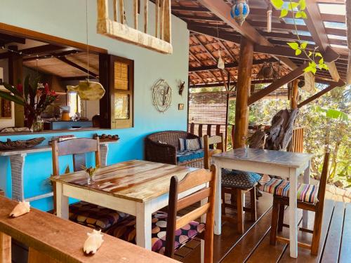 uma sala de jantar com mesas e cadeiras de madeira em CASA AITI, ex-Casa da Cris e Paulo na Ilha de Boipeba